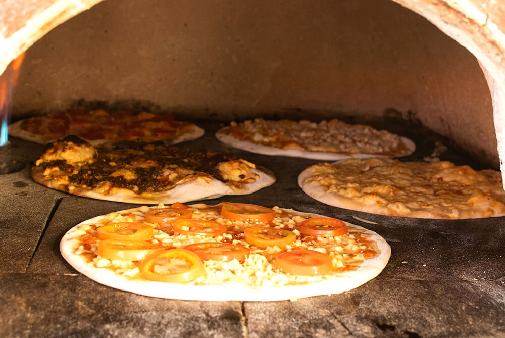 pizzas in the stone oven